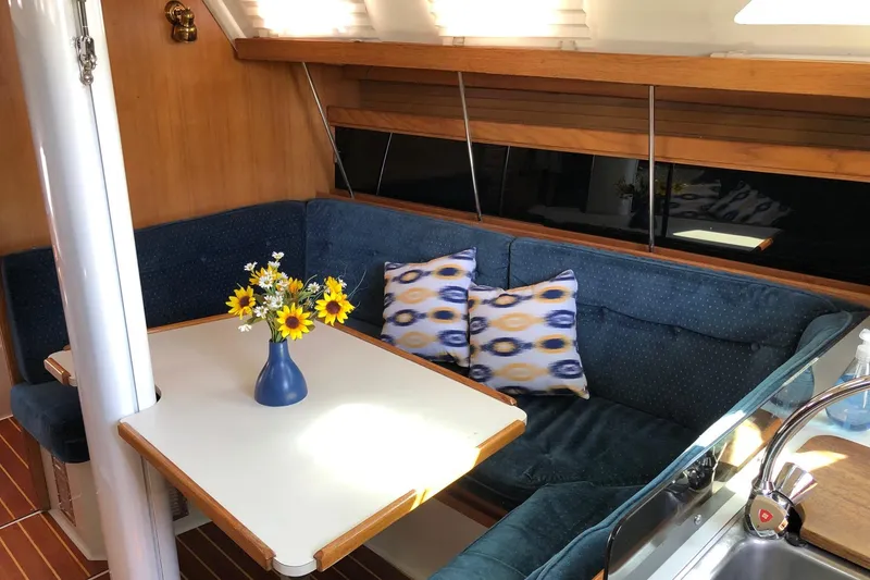 Slide: The Image of Cozy interior of 1992 Catalina 34 sailboat with blue seating and floral centerpiece. - 3