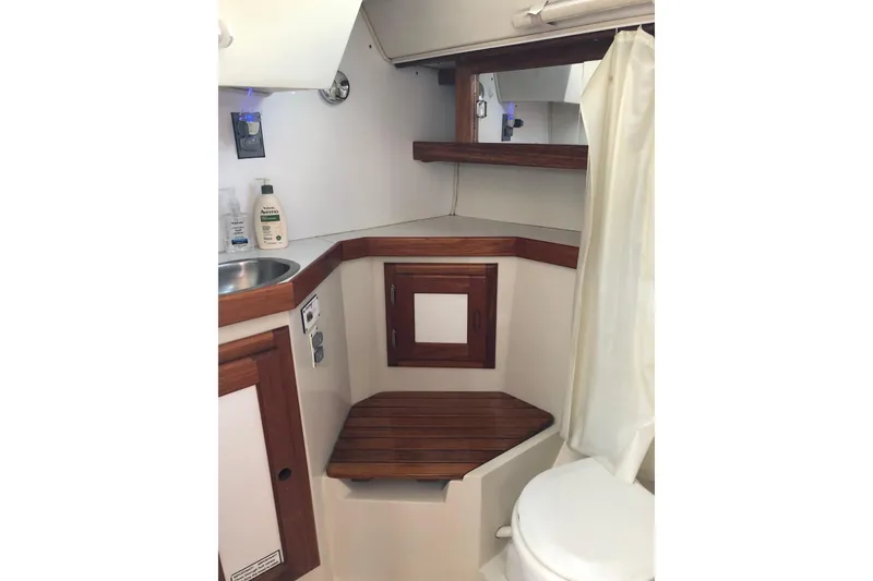 Slide: The Image of 1992 Catalina 34 yacht bathroom with wooden accents, sink, and toilet. - 8