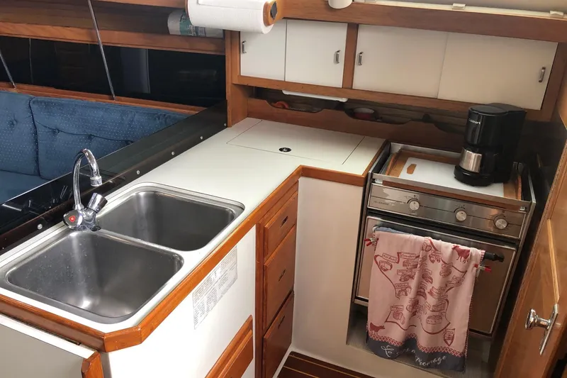Slide: The Image of Compact kitchen in a 1992 Catalina 34 sailboat with sink, stove, and coffee maker. - 9