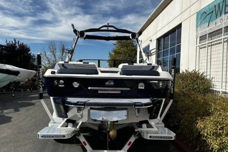 Slide: The Image of 2025 Malibu Wakesetter 23 MXZ boat parked outdoors, rear view, showcasing sleek design. - 6