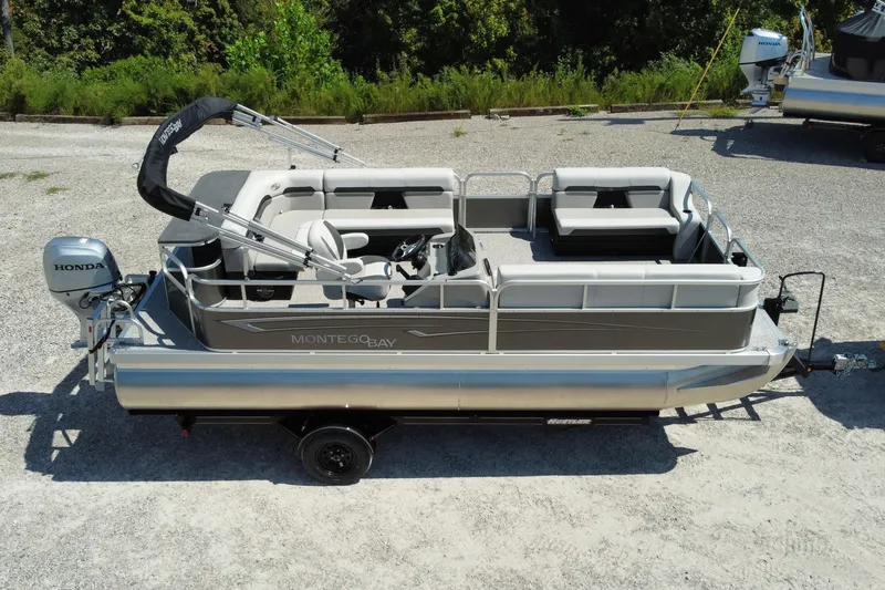 The Image of 2025 Montego Bay 90HP C8520 STD Cruise Pontoon with Honda motor, parked on gravel. - 0