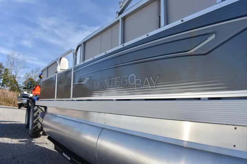 Slide: The Image of 2025 Montego Bay 90HP C8520 STD Cruise Pontoon, side view with logo detail. - 10