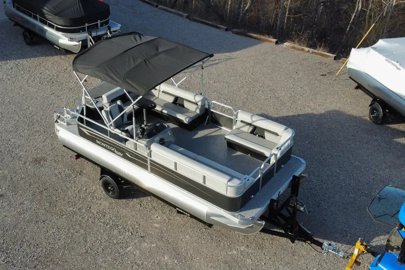 Slide: The Image of 2025 Montego Bay 90HP C8520 STD Cruise Pontoon on trailer, parked outdoors. - 3