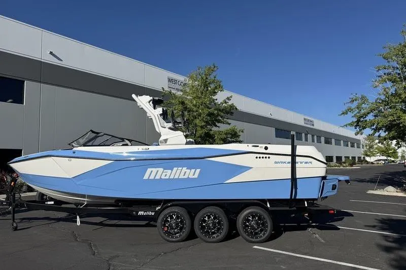 The Image of 2025 Malibu Wakesetter 26 LSV boat on trailer, parked outside a building. - 0