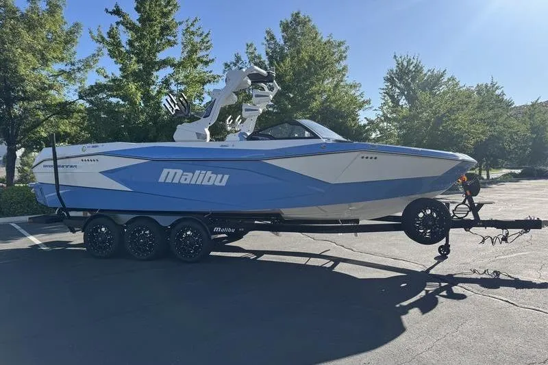 Slide: The Image of 2025 Malibu Wakesetter 26 LSV boat on trailer in sunny parking lot. - 2