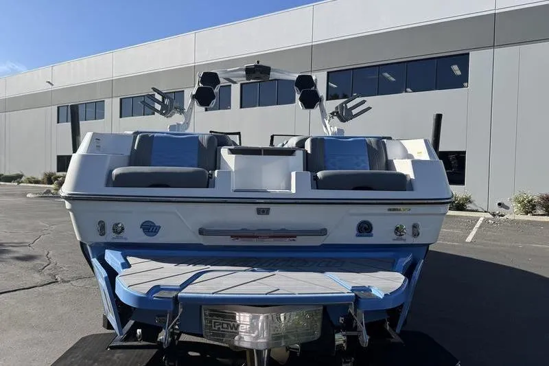 Slide: The Image of 2025 Malibu Wakesetter 26 LSV boat parked outside a modern building. - 4