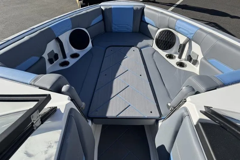 Slide: The Image of 2025 Malibu Wakesetter 26 LSV boat interior with gray and blue seating, cup holders, and speakers. - 5