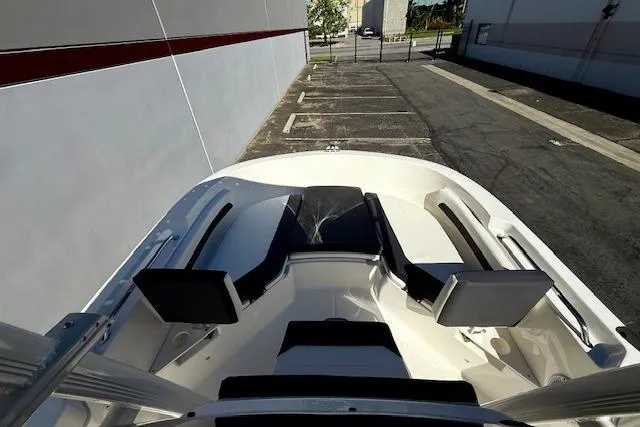Slide: The Image of 2026 Bayliner Trophy T20CC boat interior with seating, parked in an outdoor lot. - 19