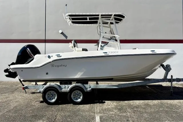 Slide: The Image of 2026 Bayliner Trophy T20CC boat on trailer, side view, white hull, outdoor setting. - 2