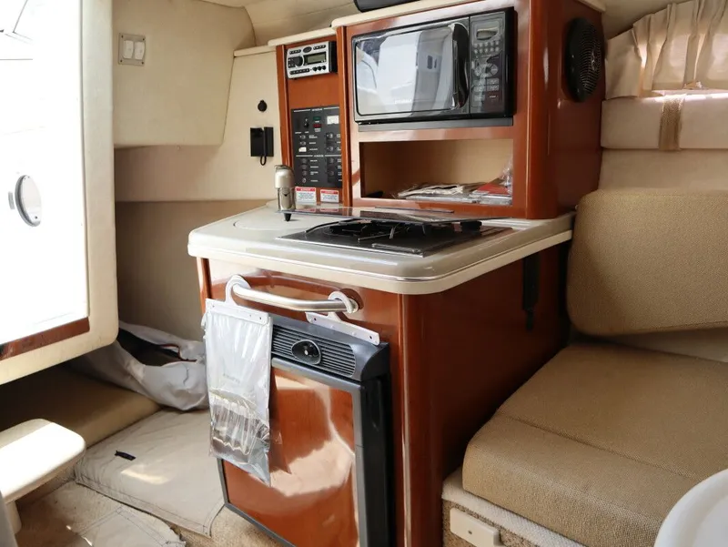 Slide: The Image of Interior of 2008 Sea Ray 240 Sundancer with kitchenette and seating area. - 20