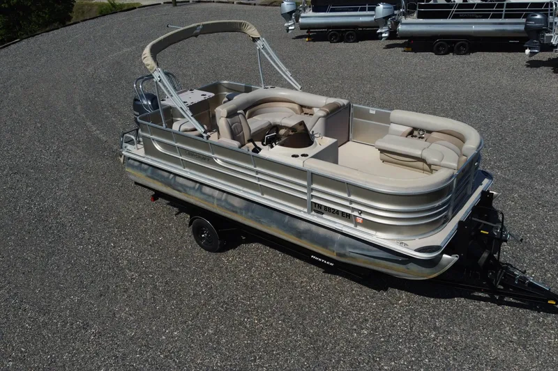 Slide: The Image of 2015 Starcraft Stardeck 216 Cruise-N-Fish pontoon boat on trailer, beige seating, outdoor setting. - 3