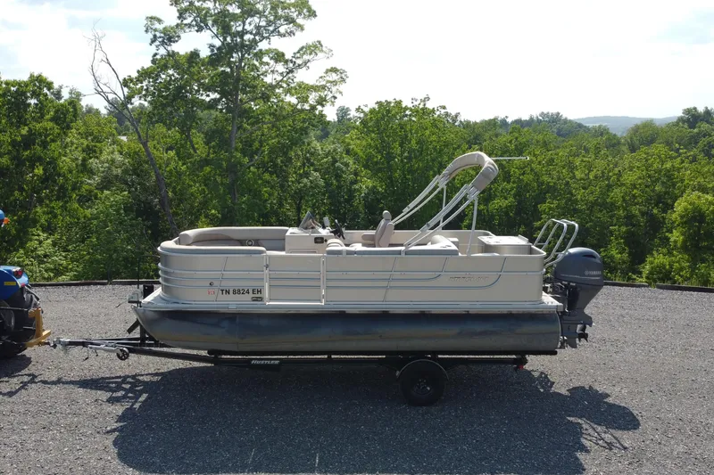 Slide: The Image of 2015 Starcraft Stardeck 216 Cruise-N-Fish pontoon boat on trailer, surrounded by lush greenery. - 4