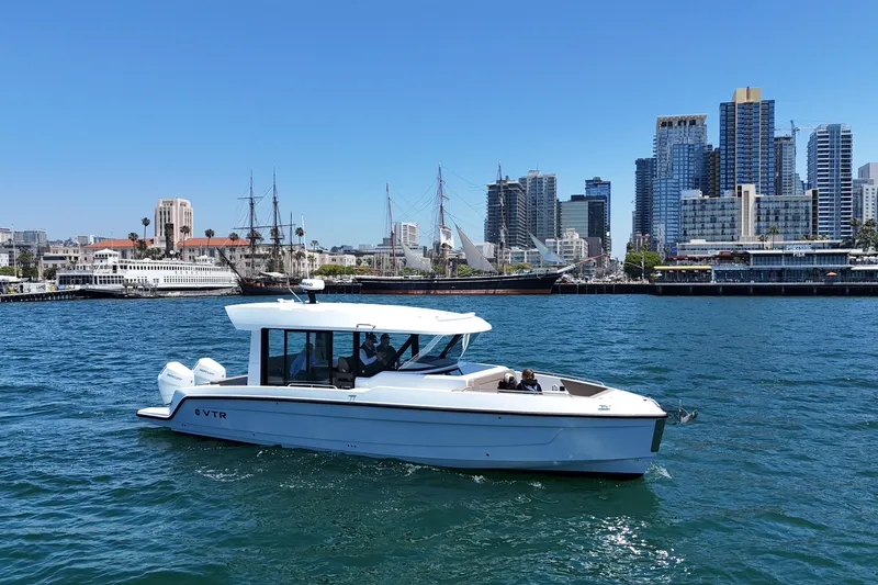 Slide: The Image of 2026 Cruisers Yachts 38 VTR on water with city skyline backdrop. - 2