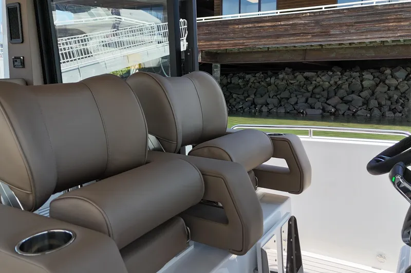 Slide: The Image of Luxury seating on 2026 Cruisers Yachts 38 VTR, featuring plush brown leather and cup holders. - 23