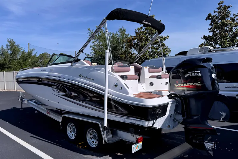 The Image of 2018 Hurricane SunDeck 2400 OB boat with Yamaha engine on trailer in parking lot. - 0