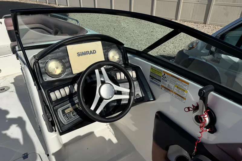 Slide: The Image of 2018 Hurricane SunDeck 2400 OB boat dashboard with steering wheel and Simrad display. - 10