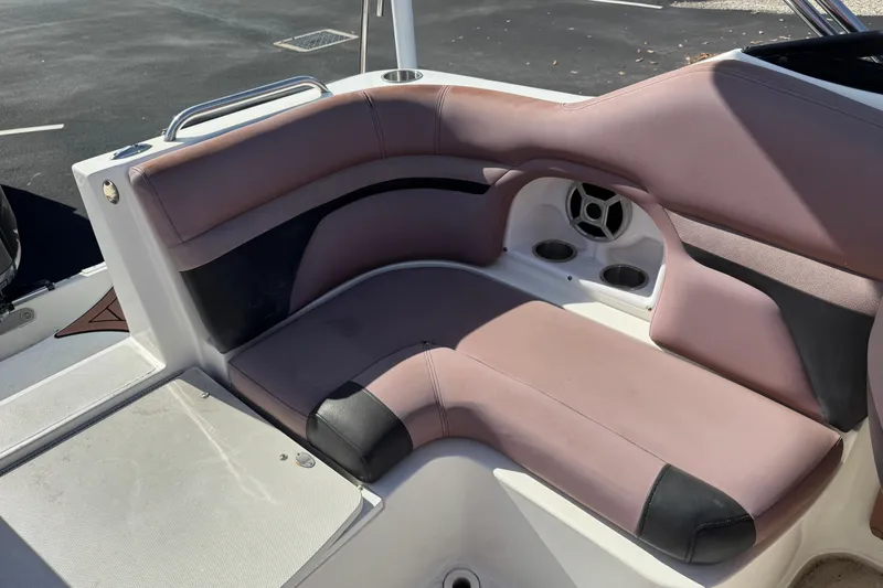 Slide: The Image of 2018 Hurricane SunDeck 2400 OB boat seating area with cup holders and speaker. - 14