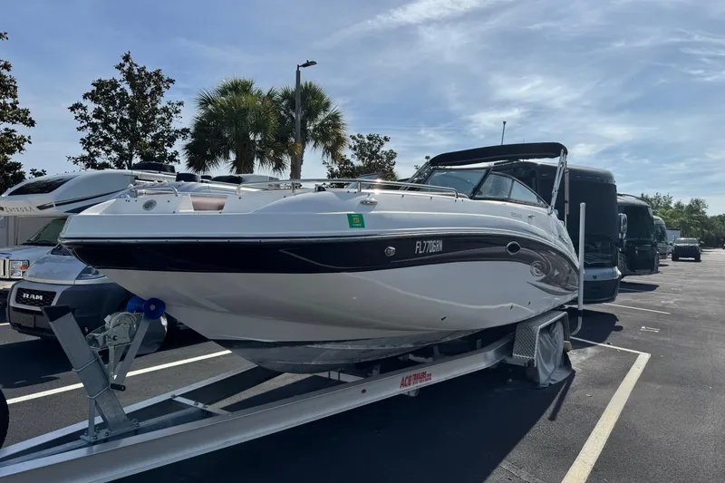 Slide: The Image of 2018 Hurricane SunDeck 2400 OB boat on trailer in parking lot, sunny day. - 2