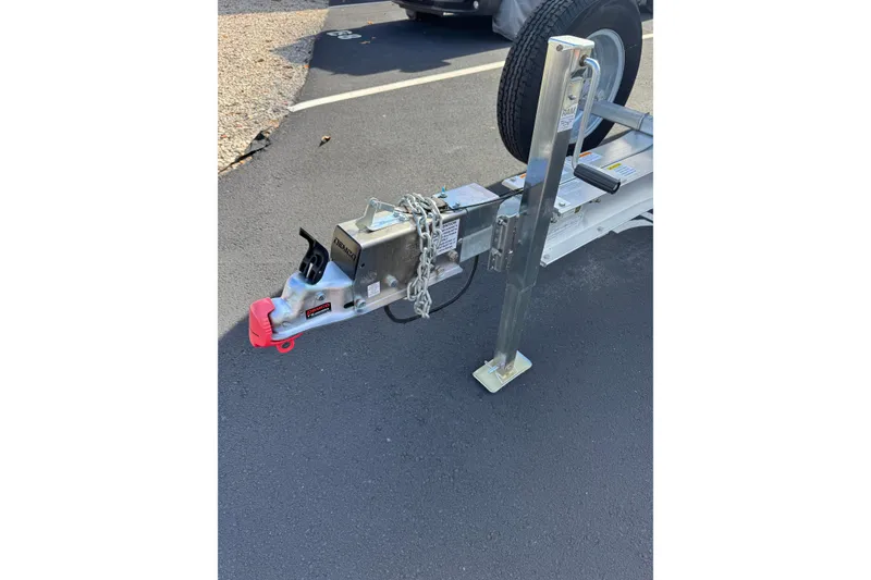 Slide: The Image of Trailer hitch and jack stand for 2018 Hurricane SunDeck 2400 OB boat on asphalt. - 23