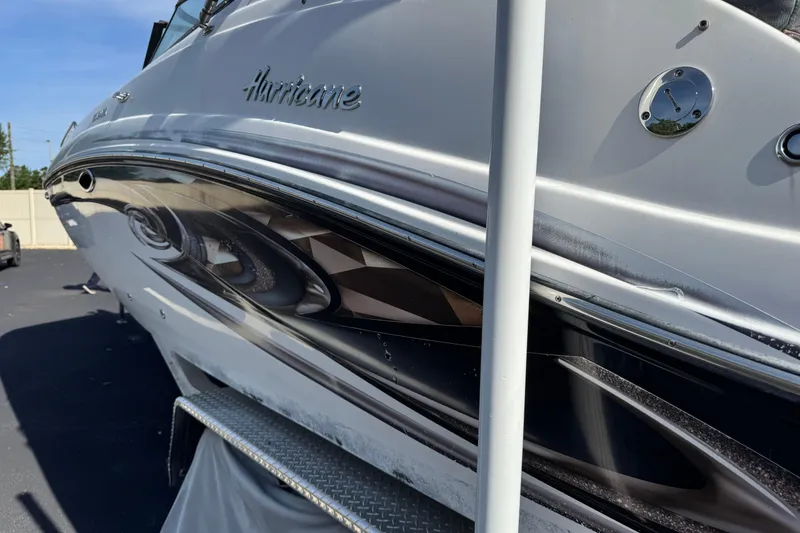 Slide: The Image of 2018 Hurricane SunDeck 2400 OB boat, sleek design, parked on pavement under clear sky. - 3