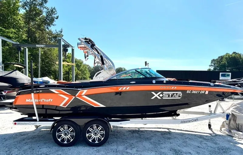 The Image of 2013 MasterCraft XStar boat on trailer outdoors. - 1