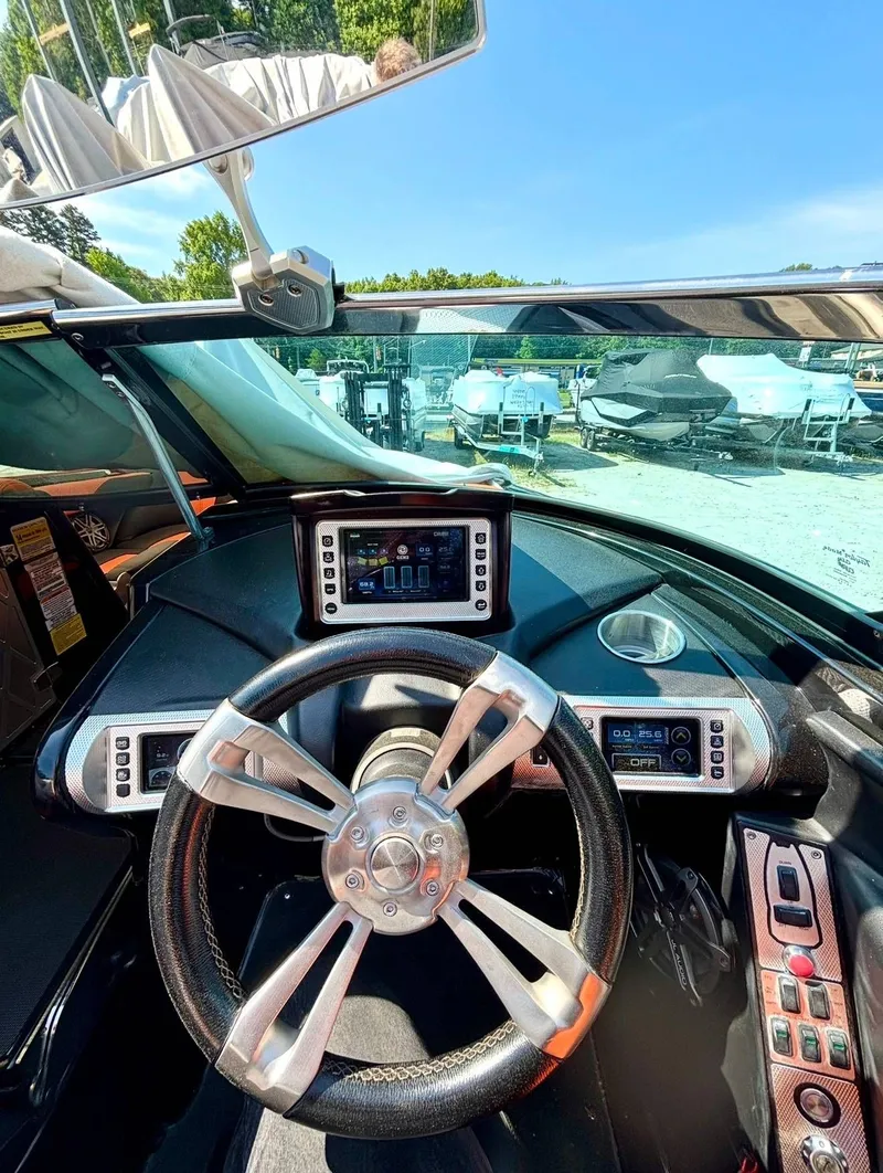 Slide: The Image of Interior view of a 2013 MasterCraft XStar boat cockpit with controls. - 10