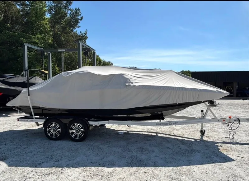 Slide: The Image of 2013 MasterCraft XStar boat covered on trailer. - 16