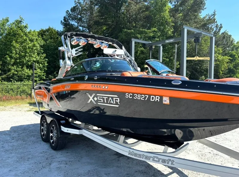 Slide: The Image of 2013 MasterCraft XStar boat parked on trailer outdoors. - 3