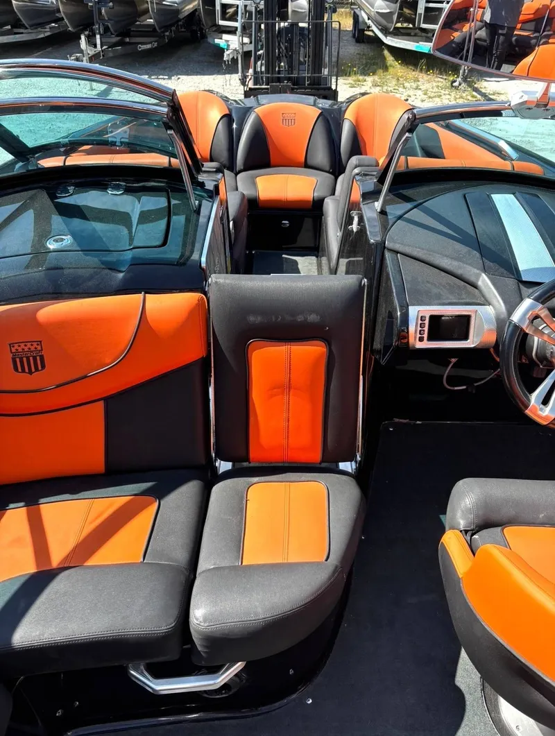 Slide: The Image of Interior of a 2013 MasterCraft XStar boat with orange and black seating. - 7