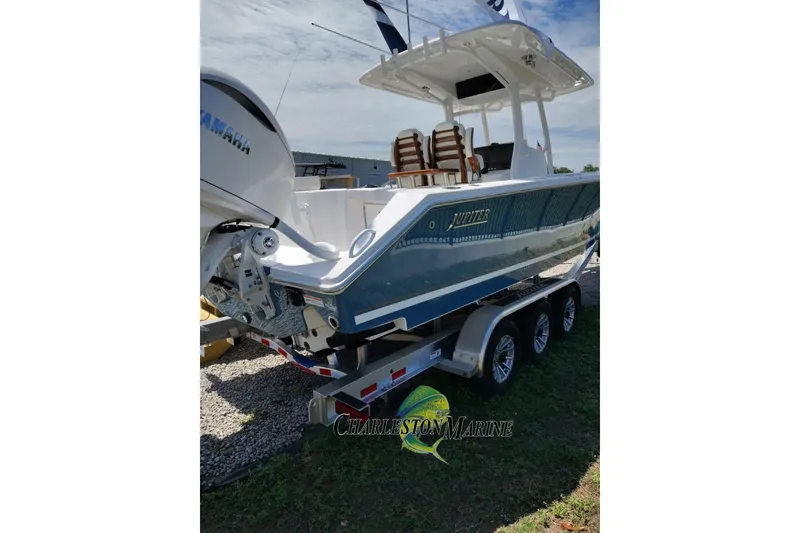 Slide: The Image of 2026 Jupiter 30 boat on trailer with Yamaha engine, displayed outdoors. - 2