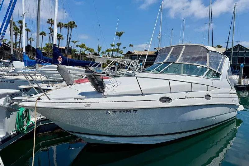 The Image of 2002 Cruisers Yachts 2870 Express docked in marina under clear blue sky. - 0