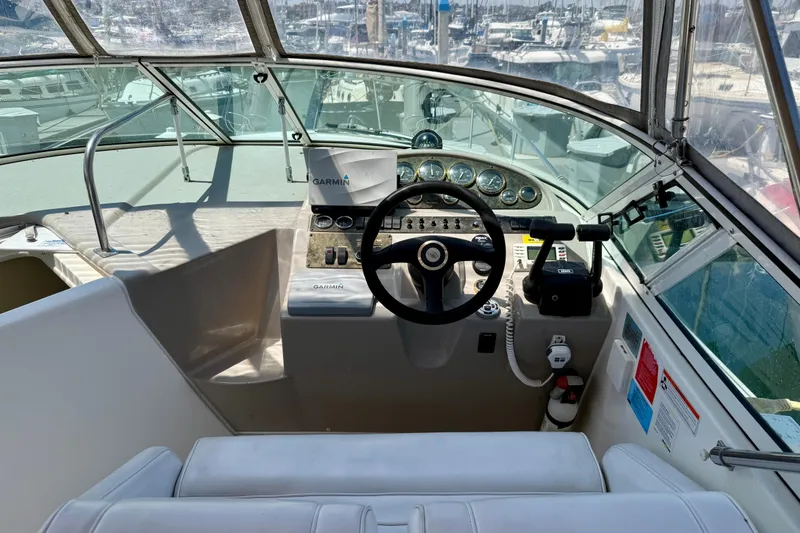 Slide: The Image of 2002 Cruisers Yachts 2870 Express helm with Garmin navigation, steering wheel, and control panel. - 10