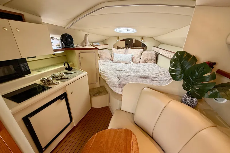 Slide: The Image of Interior of 2002 Cruisers Yachts 2870 Express with cozy bed, kitchenette, and seating area. - 14