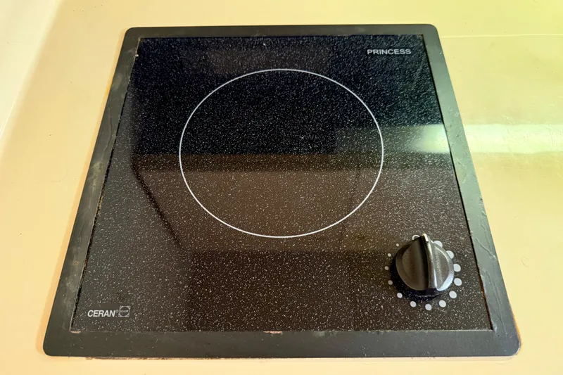 Slide: The Image of Ceramic cooktop on 2002 Cruisers Yachts 2870 Express, featuring a single burner and control knob. - 19