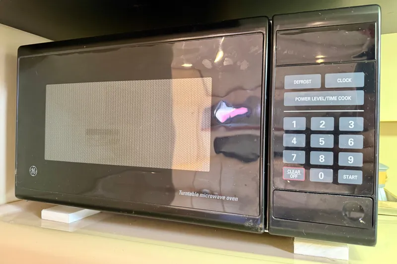 Slide: The Image of A black GE turntable microwave oven with digital keypad and control buttons. - 20