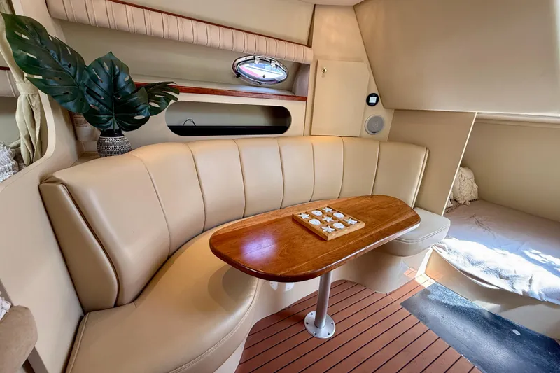 Slide: The Image of Interior of 2002 Cruisers Yachts 2870 Express with beige seating and wooden table. - 21