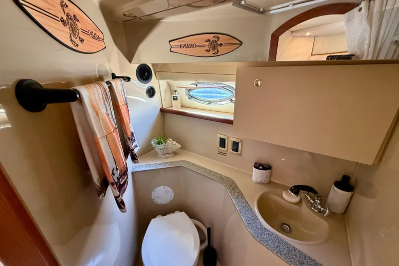 Slide: The Image of 2002 Cruisers Yachts 2870 Express bathroom with sink, toilet, and decorative elements. - 23