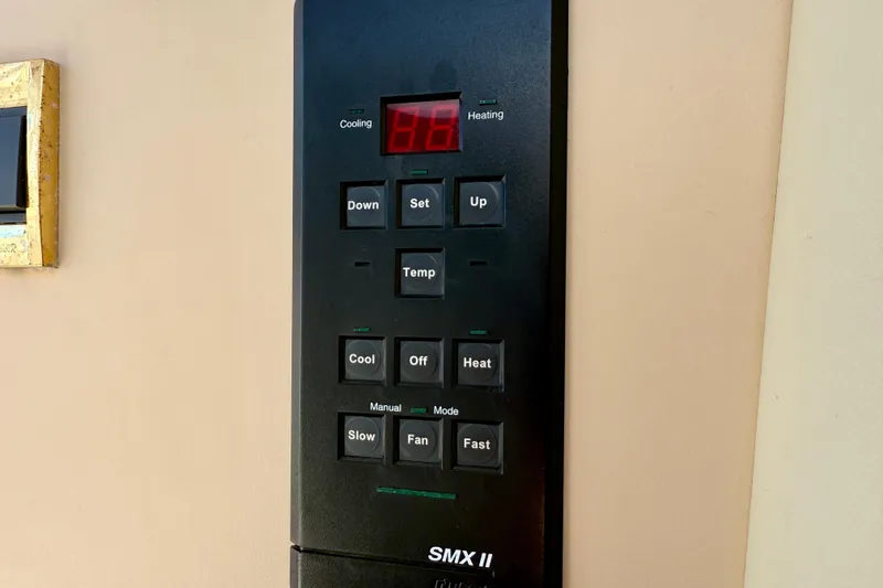 Slide: The Image of Control panel of a 2002 Cruisers Yachts 2870 Express, featuring temperature and fan settings. - 27