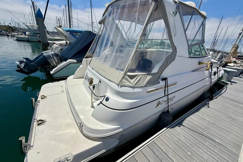 Slide: The Image of 2002 Cruisers Yachts 2870 Express docked at marina, featuring clear canopy and sleek design. - 3