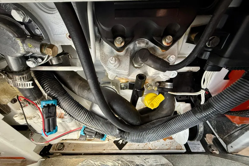 Slide: The Image of Engine compartment of a 2002 Cruisers Yachts 2870 Express, showcasing hoses and components. - 33