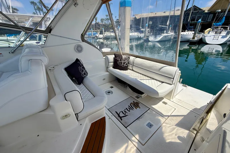 Slide: The Image of 2002 Cruisers Yachts 2870 Express interior with white seating and marina view. - 7