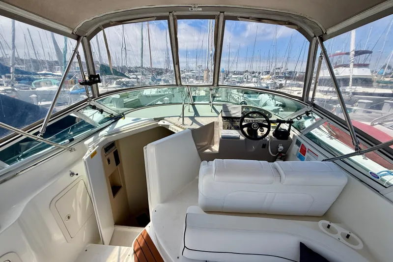 Slide: The Image of 2002 Cruisers Yachts 2870 Express cockpit with white seating and marina view. - 9