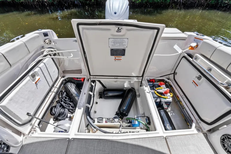 Slide: The Image of Open storage compartments in a 2026 Solara S-250 Coupe boat, showcasing equipment and wiring. - 21
