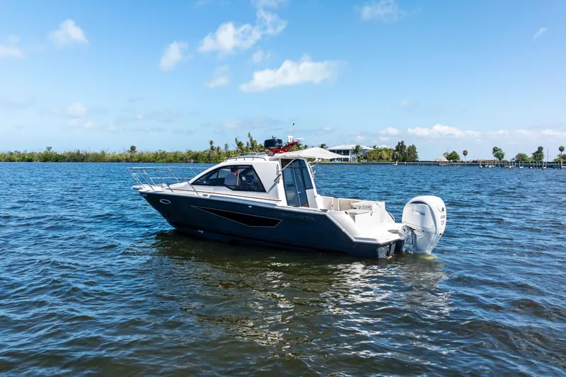 Slide: The Image of 2026 Solara S-250 Coupe boat on calm water under clear blue sky. - 3