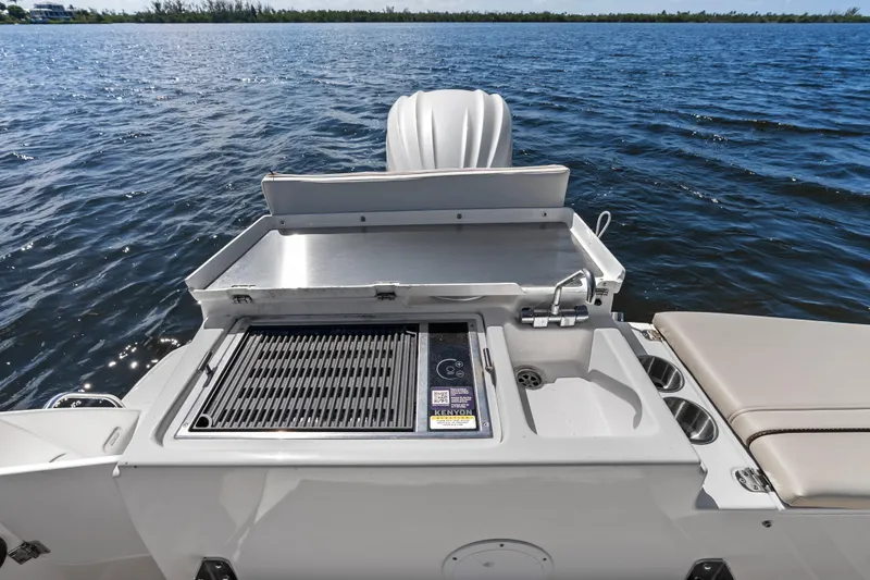 Slide: The Image of Outdoor grill and sink on 2026 Solara S-250 Coupe boat, overlooking serene water. - 8