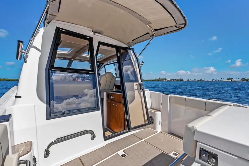 Slide: The Image of 2026 Solara S-250 Coupe boat interior with open cabin door, overlooking serene blue waters. - 9