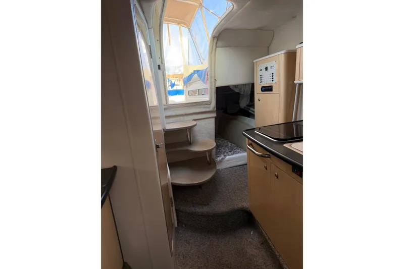 Slide: The Image of Interior view of 2001 Maxum 2800 SCR boat, featuring compact kitchen and stairs. - 7