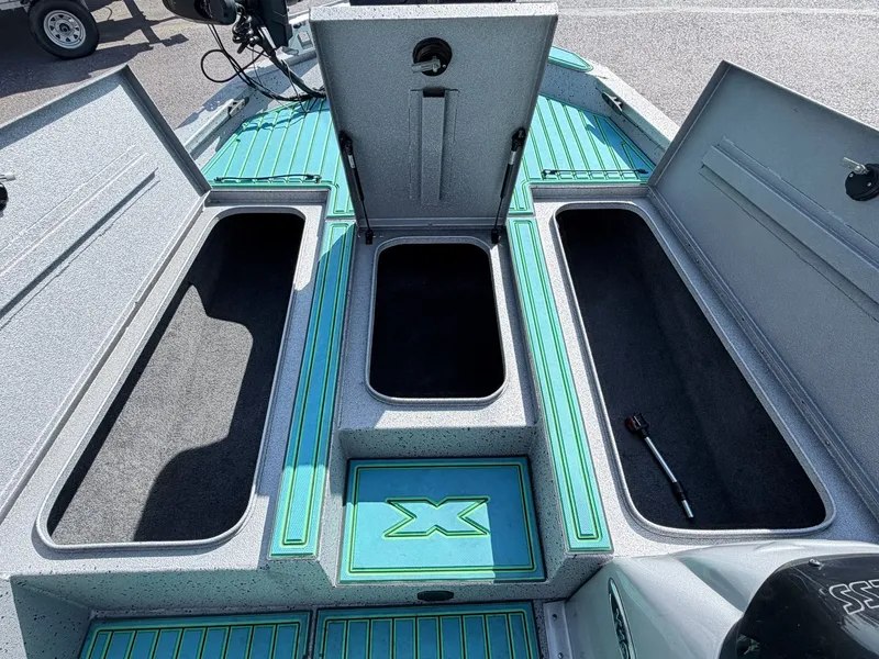 Slide: The Image of 2017 Xpress X19 boat with open storage compartments and green deck. - 12