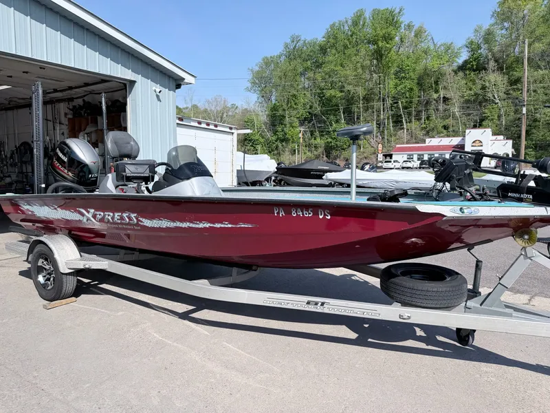 Slide: The Image of Red 2017 Xpress X19 boat on trailer outside garage. - 37
