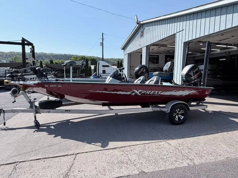 Slide: The Image of Red 2017 Xpress X19 boat on trailer outside garage. - 9